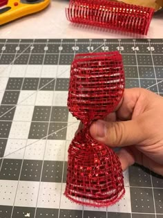 a person is making some red sequins