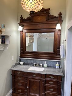 a bathroom with a vanity, mirror and lights on the ceiling above it's sink