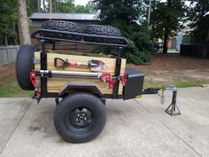 a utility trailer is parked on the sidewalk in front of a house with an attached tool box