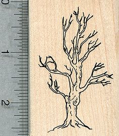 a rubber stamp with a tree and bird on it, in front of a ruler