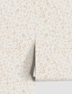 the wallpaper is white and has gold leaves on it, as well as a beige background