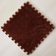 a close up of a brown rug on a white surface