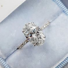 a diamond ring sitting on top of a blue cloth