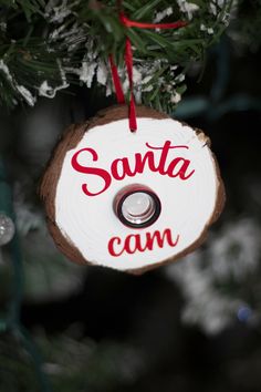 a wooden ornament hanging from a christmas tree with santa can written on it