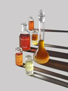 an assortment of different colored liquids in glass flasks and beakles on a metal rack