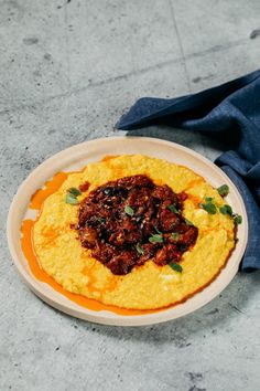 a white plate topped with food on top of a table next to a blue cloth