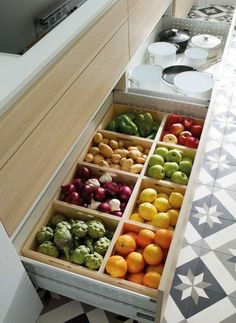 an open drawer in a kitchen filled with lots of fruits and vegtables