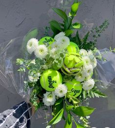 a bouquet of flowers and tennis balls with the word mom written on them in black lettering