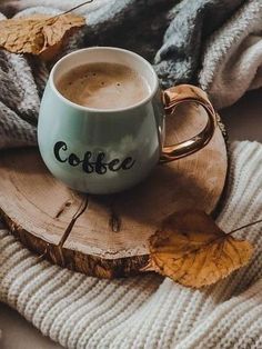 a cup of coffee sitting on top of a wooden slice