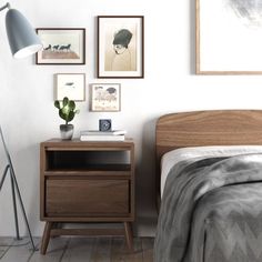 a bed room with a neatly made bed next to a night stand and a lamp