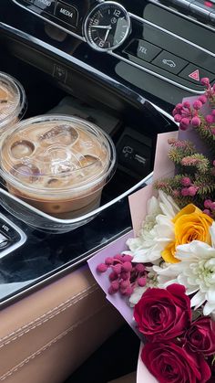 two pies and flowers are sitting on the dashboard of a car, next to a bouquet of flowers