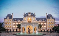 a large white building with a fountain in front of it at night time and lit up by lights