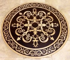 a black and gold plate sitting on top of a tile floor