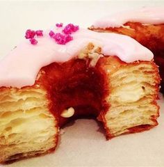 a half eaten doughnut with pink icing and sprinkles