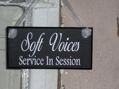 a sign that says soft voice service in session hanging from the side of a door