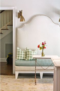 a living room with a couch, table and flowers on the coffee table in front of it