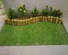 a wooden fence made out of logs with flowers in the middle and grass growing between them