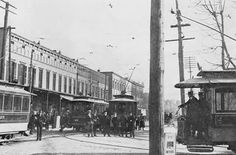 an old black and white photo of trolleys on the tracks in front of buildings