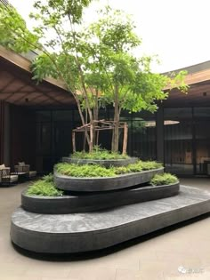 an outdoor area with trees and benches in the center, surrounded by large concrete slabs