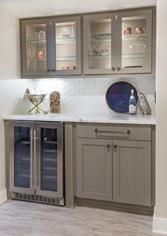 a kitchen with gray cabinets and white counter tops