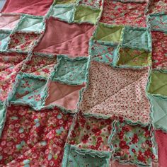 an old quilt is laying on top of a tablecloth that has been made into a blanket