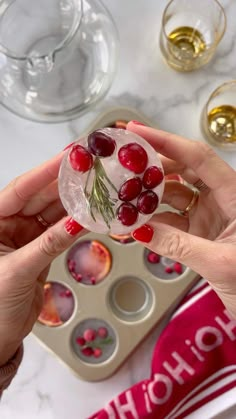 a woman holding up a glass with cherries on it