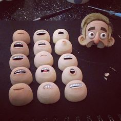 a bunch of fake heads sitting on top of a table next to doughnuts