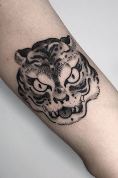 a black and white tiger tattoo on the arm