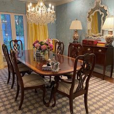 a dining room table with chairs and a chandelier