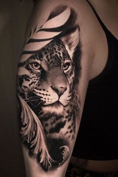 a woman's arm with a black and white tattoo on it, featuring a leopard