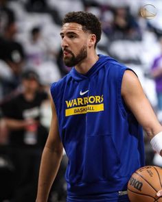 a man holding a basketball while wearing a blue shirt and white glove on his left hand