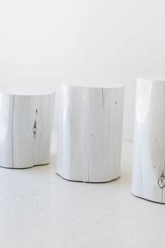 three white vases sitting next to each other on a table