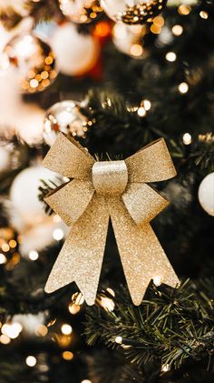 a gold bow on top of a christmas tree