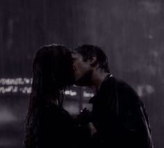 a man and woman kissing in the rain