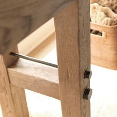 a close up of a wooden bench with a basket in the background