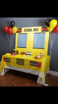 a school bus themed birthday party with yellow table cloths and red, black, and white balloons