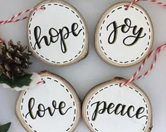 four wooden ornaments with the words hope, love, and peace hanging from twine