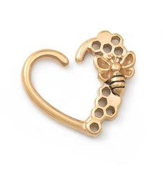 a gold heart shaped brooch with a bee on it