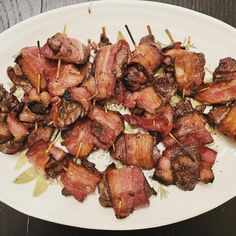 bacon wrapped in toothpicks on a white plate