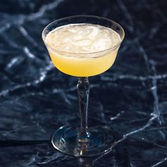 a glass filled with yellow liquid on top of a table