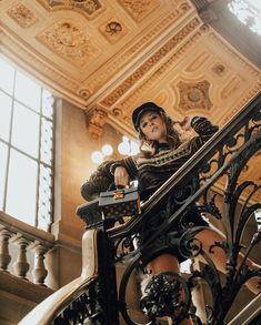 a woman sitting on top of a stair case next to a window in a building