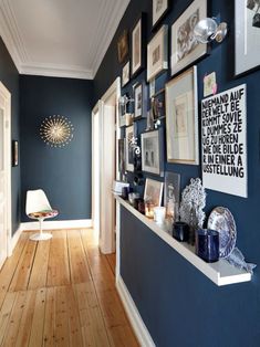 the hallway is decorated in blue and white with pictures on the wall, framed by frames