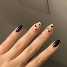 a woman's hand with black and white nail polish on it, holding up her nails