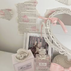 a white table topped with a mirror next to a box and pink bowtie on top of it