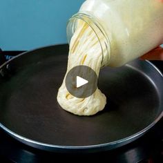 someone is pouring batter into a skillet on top of the stove to make pancakes