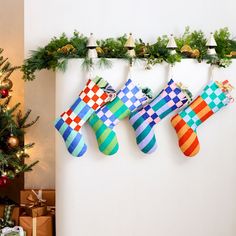 christmas stockings hanging on a wall next to a christmas tree