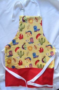 a yellow apron with red and white trim on it, sitting on top of a bed