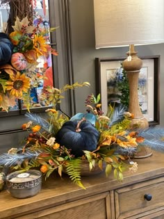 a wooden dresser topped with lots of fall decorations