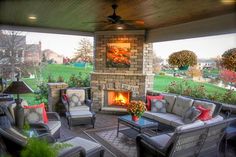 an outdoor living area with couches, chairs and a fire place in the center