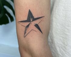 a black and white star tattoo on the arm